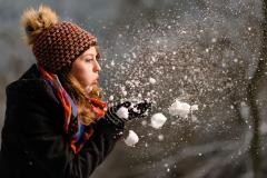 Vorschaubild Mädchen bläst Schnee von ihren Händen