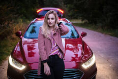 Vorschaubild Mädchen abends in rosa Jacke stehend vor Auto