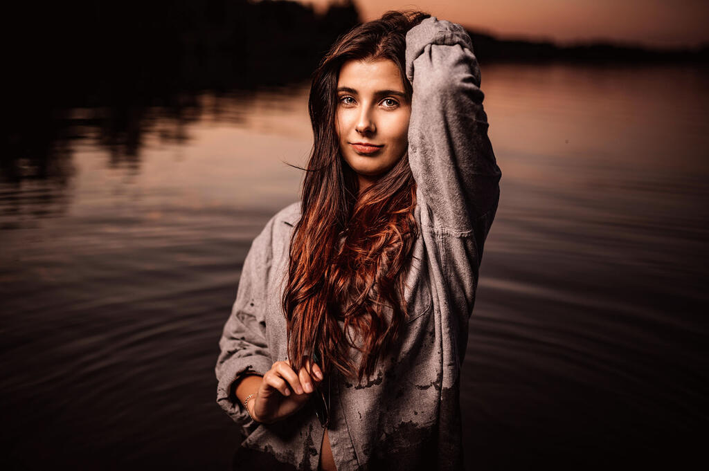 Mädchen im Abendlicht vor einem See